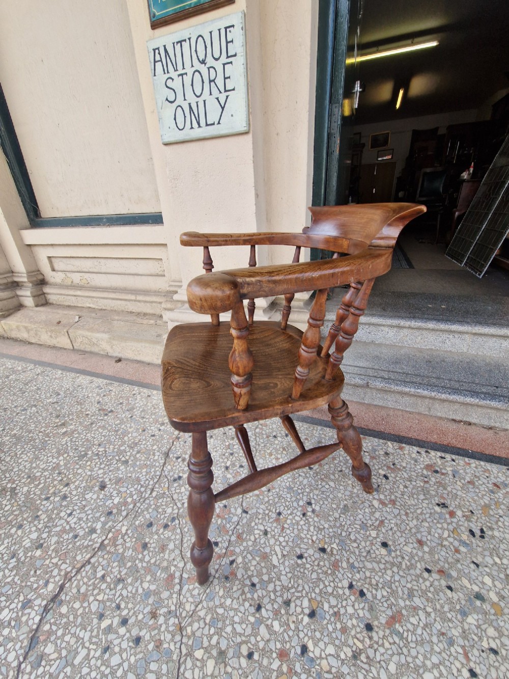 A pair of antique warm brown ash and elm captains armchairs featuring curved horseshoe backrests, turned spindles, shaped saddle seats, and turned legs. View VIII