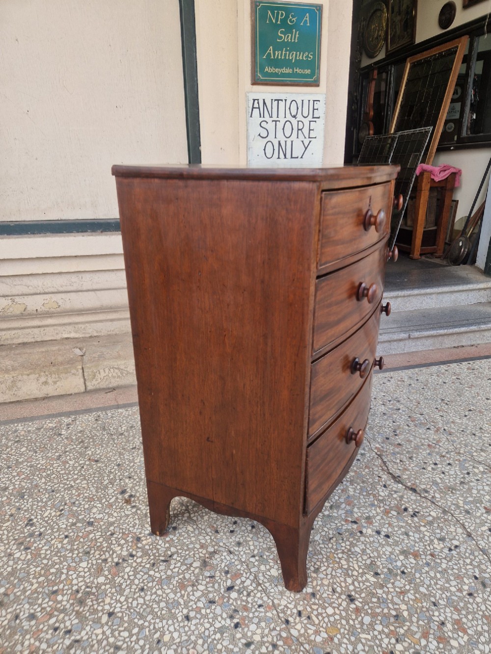 A Georgian mahogany bow-fronted chest of drawers featuring two short over three long graduated drawers with turned wooden knobs and splayed bracket feet. View III