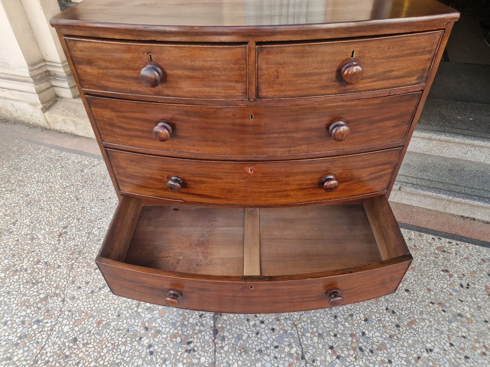 A Georgian mahogany bow-fronted chest of drawers featuring two short over three long graduated drawers with turned wooden knobs and splayed bracket feet. View VIII