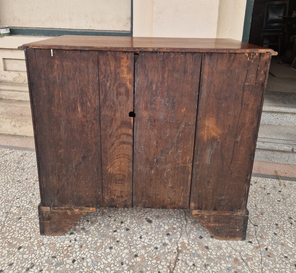 An 18th-century Georgian mahogany kneehole desk featuring a long top drawer, six flank drawers, a central recessed cupboard, brass drop handles, and bracket feet. View IX
