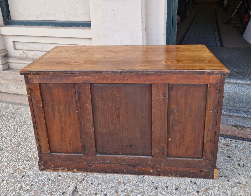 An Arts and Crafts pitch pine pedestal desk featuring nine drawers with hand-painted line borders and metal ring handles. View VII