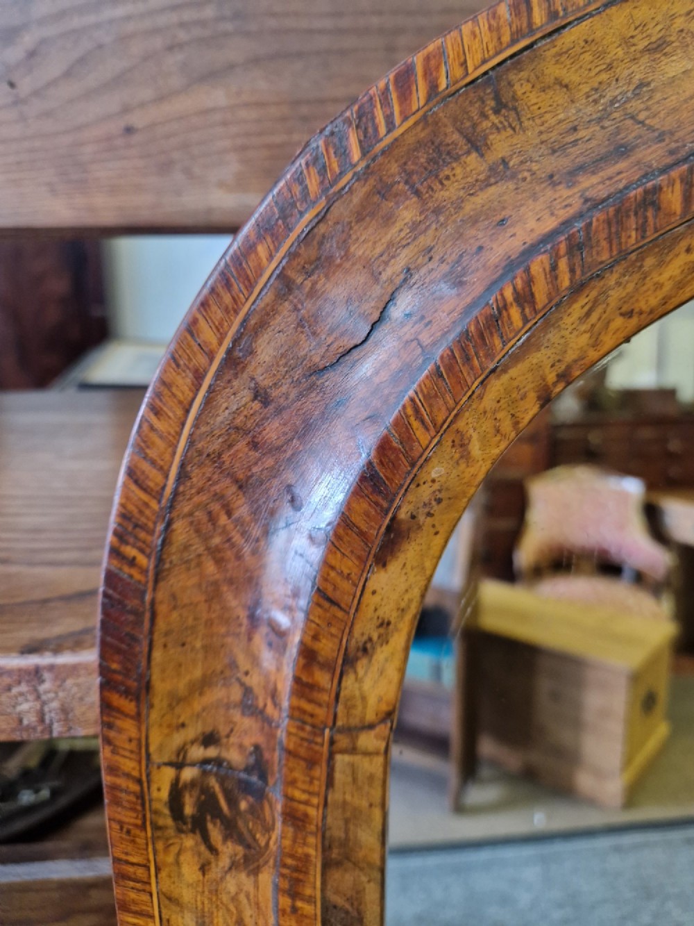 A Victorian burr walnut overmantel mirror featuring a curved arched top frame resting on flat moulding blocks. View II