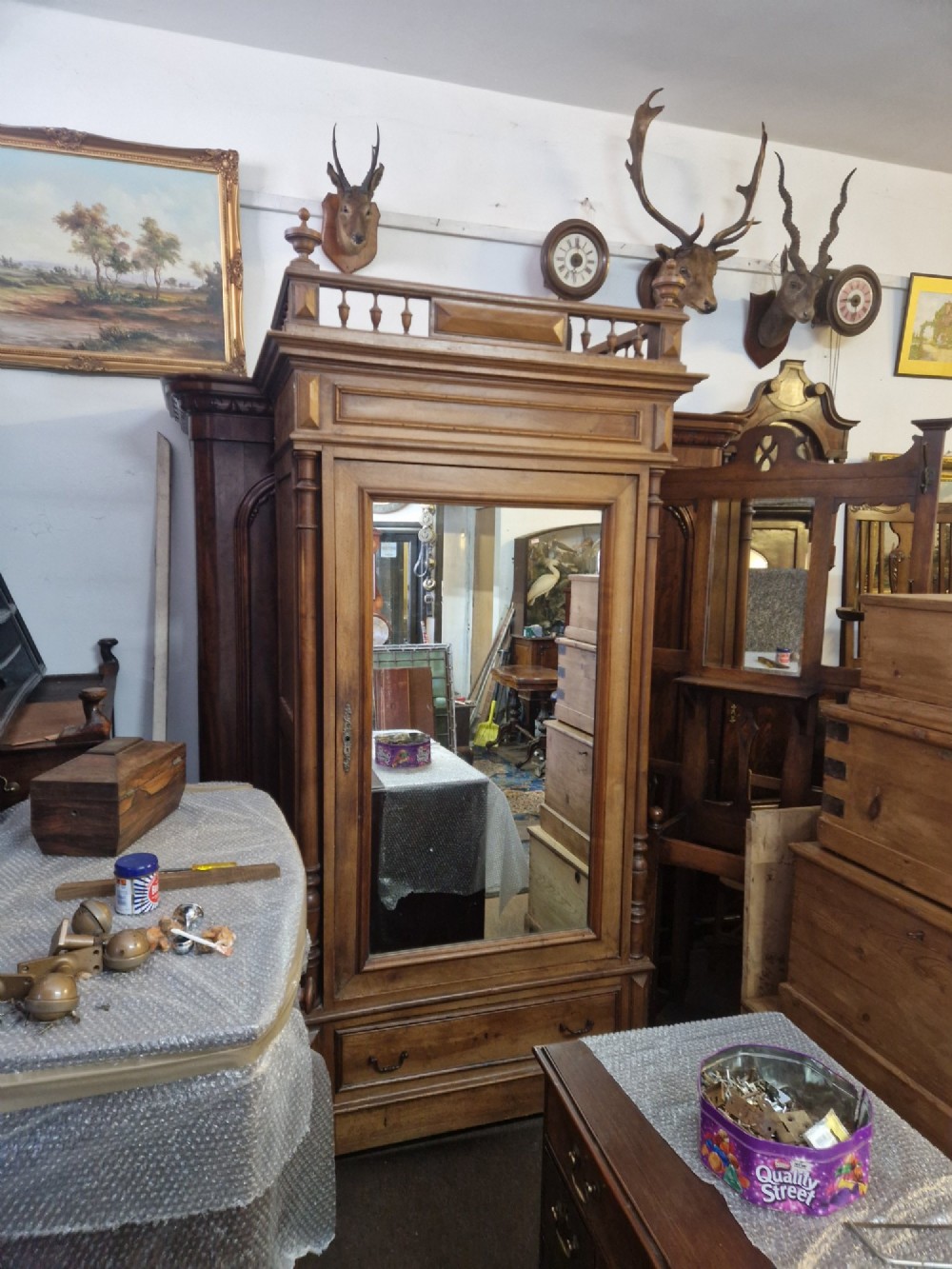 An antique burr walnut single-door armoire with a central bevelled mirror, flanking turned columns, and a lower drawer. View II