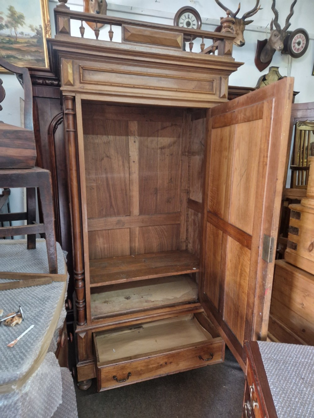 An antique burr walnut single-door armoire with a central bevelled mirror, flanking turned columns, and a lower drawer. View III