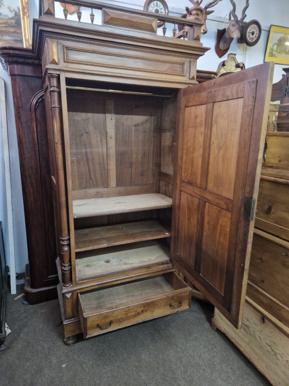 An antique burr walnut single-door armoire with a central bevelled mirror, flanking turned columns, and a lower drawer. View VII