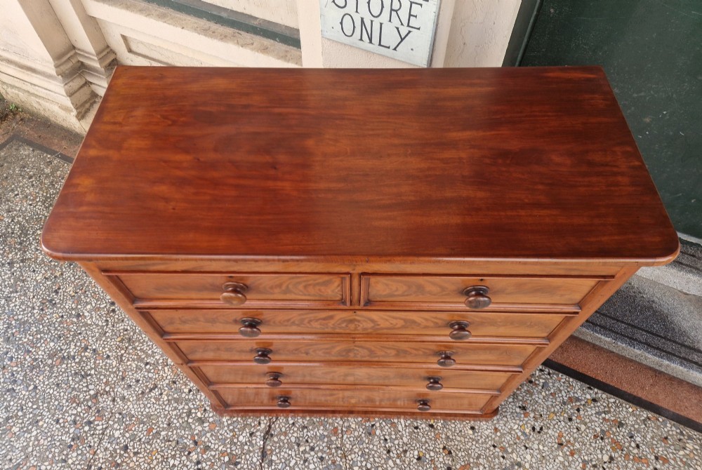 A tall Victorian mahogany chest of drawers featuring two short upper drawers above four long graduating drawers with turned wooden knobs and a plinth base. View IV