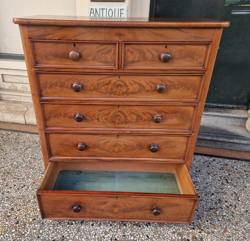 A tall Victorian mahogany chest of drawers featuring two short upper drawers above four long graduating drawers with turned wooden knobs and a plinth base. View VI