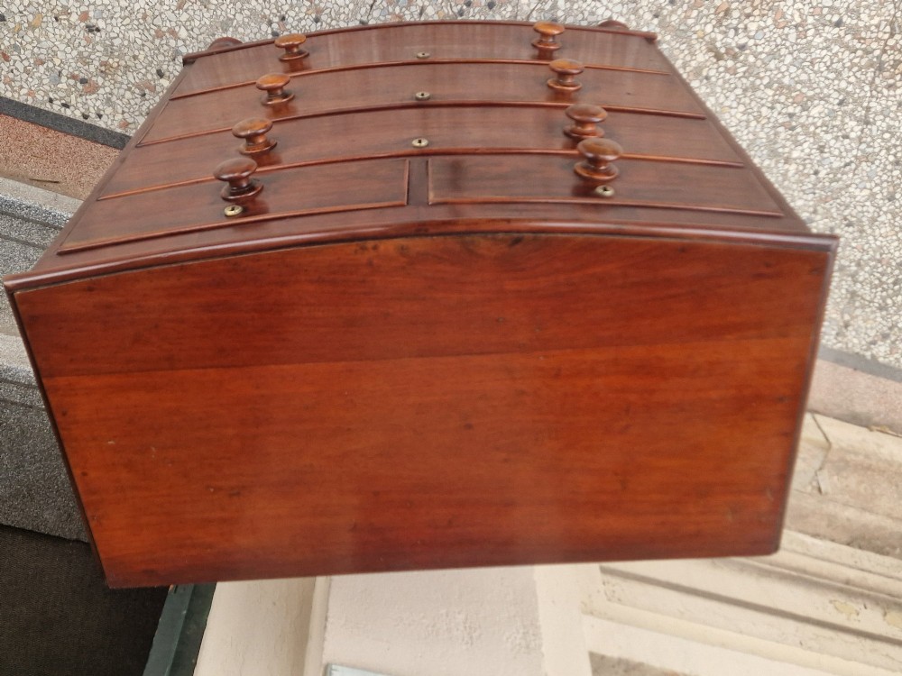 A Victorian mahogany bow fronted chest of drawers featuring two short over three long drawers with turned wooden handles and brass escutcheons on turned feet. View IX