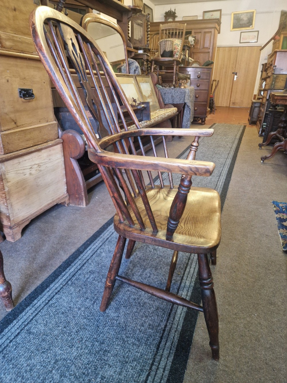 An antique ash and elm Windsor armchair with a hoop back, central pierced splat, turned spindles, shaped wooden seat, and turned legs joined by an H-stretcher. View III