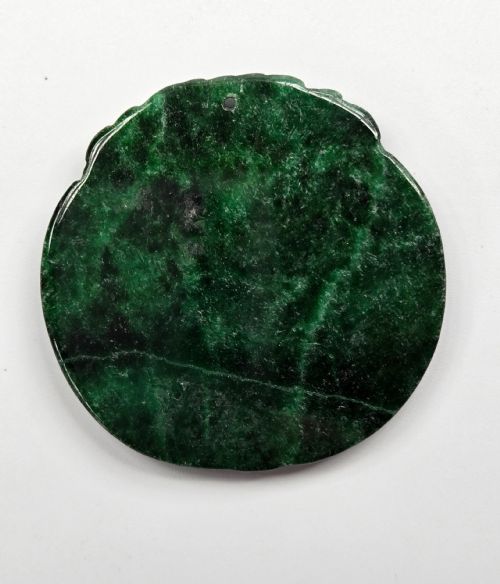 fig 2. A circular dark green carved jadeite pendant featuring stylised double dragon motifs with openwork details and a suspension hole at the top.