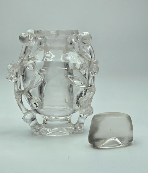 fig 1. A 19th-century Chinese carved clear rock crystal snuff bottle featuring openwork prunus branches around the body and a smooth matching stopper.