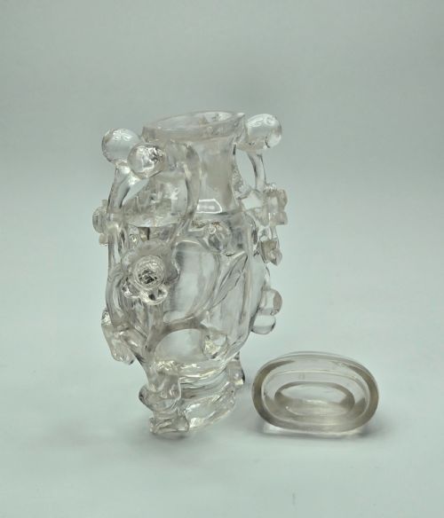 fig 4. A 19th-century Chinese carved clear rock crystal snuff bottle featuring openwork prunus branches around the body and a smooth matching stopper.