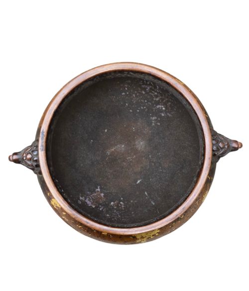 fig 6. A dark brown cast bronze incense burner featuring irregular gold splash decoration and detailed beast mask handles on either side.