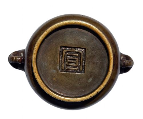 fig 4. A miniature dark bronze censer featuring a rounded body, twin elephant head handles with curved trunks, and a circular raised footring.