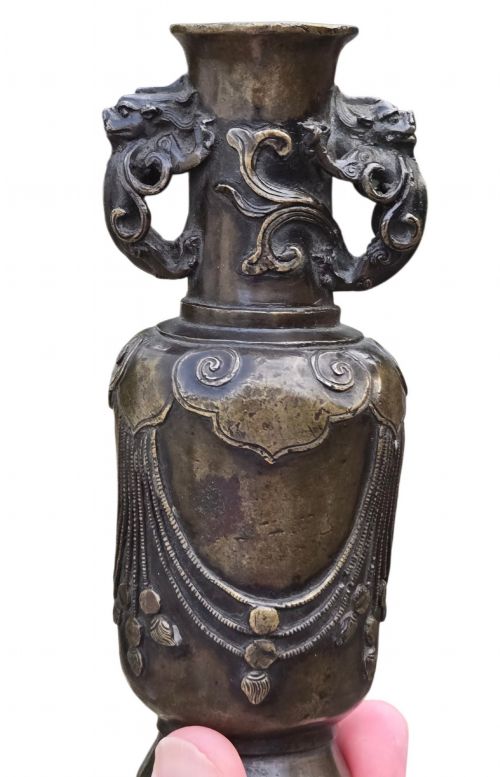 fig 2. A patinated cast bronze Chinese vase featuring stylised dragon-head handles and raised Yingluo beaded tassels.