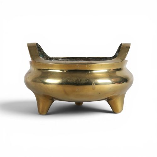 fig 1. A heavy gold-toned cast bronze tripod censer featuring two upright loop handles and conical feet.
