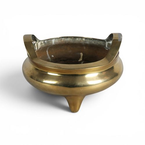 fig 2. A heavy gold-toned cast bronze tripod censer featuring two upright loop handles and conical feet.