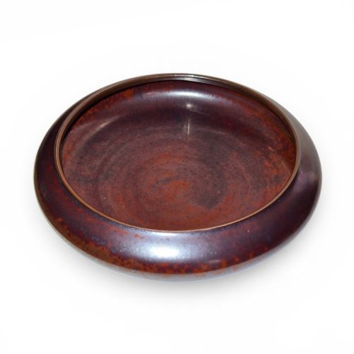 fig 3. A low compressed circular ceramic brush washer featuring a dark reddish-brown iron rust glaze with subtle metallic speckling.