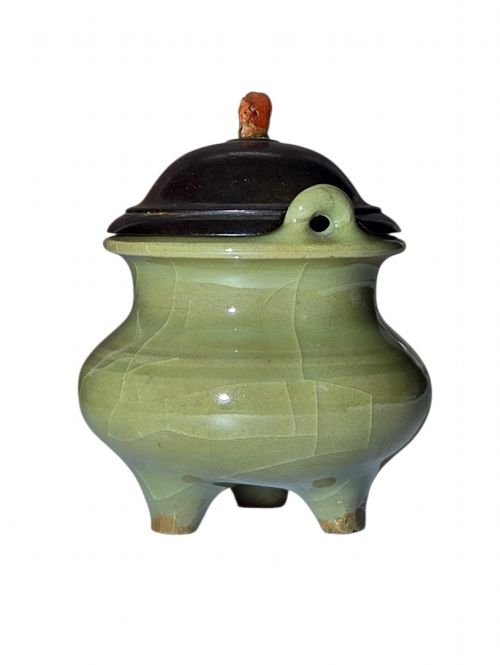 fig 2. A miniature pale celadon green tripod censer with a distinct crackle glaze, fitted with a dark wood cover and a carved red coral finial.