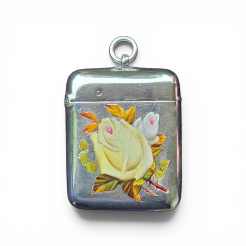 fig 1. A rectangular sterling silver vesta case featuring hand-painted yellow and white roses in enamel with a top suspension loop.