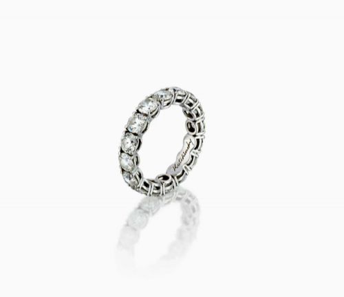 fig 4. A platinum full eternity ring set with round brilliant diamonds, displayed inside its original black leather Kutchinsky box.