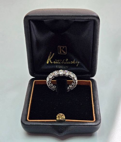 fig 1. A platinum full eternity ring set with round brilliant diamonds, displayed inside its original black leather Kutchinsky box.