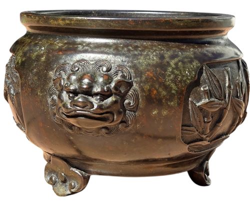fig 2. A dark patinated cast bronze incense burner featuring raised relief panels of bamboo and beast mask side handles.