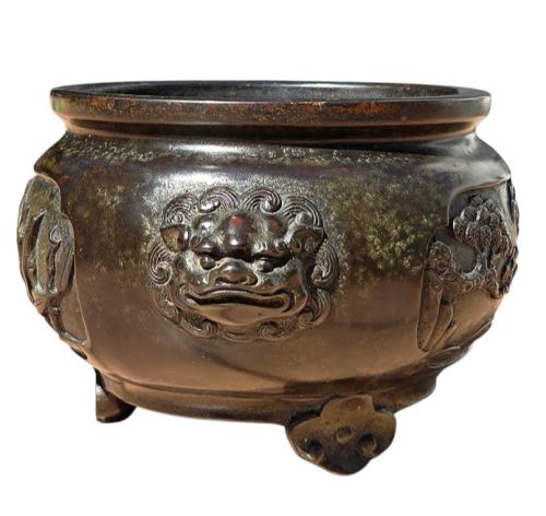 fig 3. A dark patinated cast bronze incense burner featuring raised relief panels of bamboo and beast mask side handles.