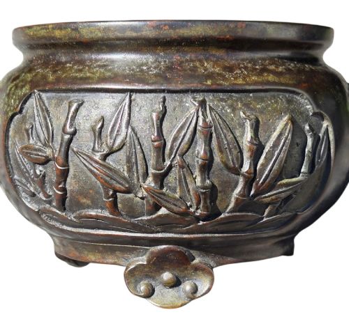 fig 5. A dark patinated cast bronze incense burner featuring raised relief panels of bamboo and beast mask side handles.