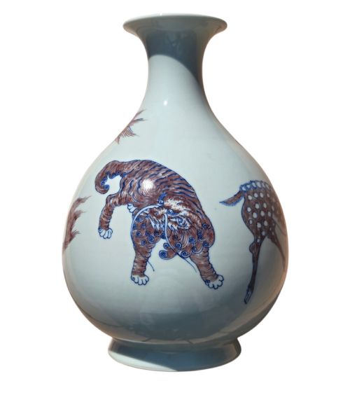 fig 1. A white porcelain garlic-mouth vase featuring underglaze blue and copper-red painted depictions of mythical beasts.
