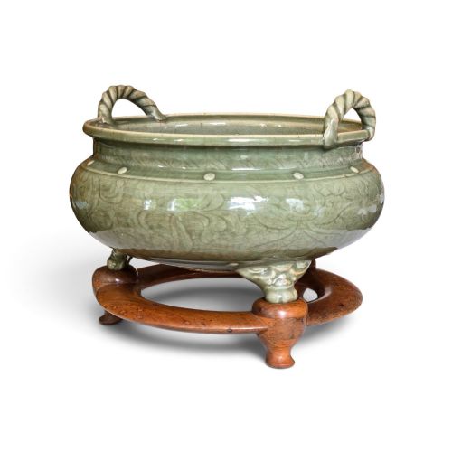 fig 2. A green glazed Longquan celadon tripod censer with carved floral scrollwork beneath the glaze, twin rope-twist handles, and three mask feet.