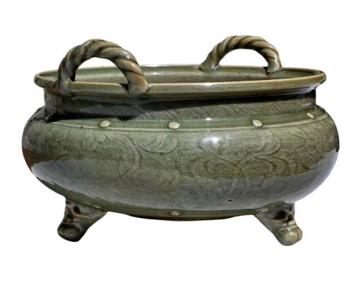 fig 3. A green glazed Longquan celadon tripod censer with carved floral scrollwork beneath the glaze, twin rope-twist handles, and three mask feet.