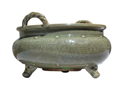 fig 5. A green glazed Longquan celadon tripod censer with carved floral scrollwork beneath the glaze, twin rope-twist handles, and three mask feet.