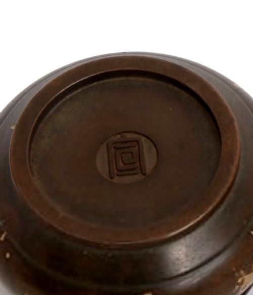 fig 2. A dark brown bronze circular censer featuring gold splash decoration, a reticulated lattice cover with a spherical finial, and a matching footed bronze stand.