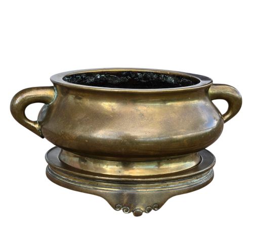 fig 6. A heavy Chinese bronze ritual censer featuring twin loop handles and resting on a matching fitted base with shaped feet.