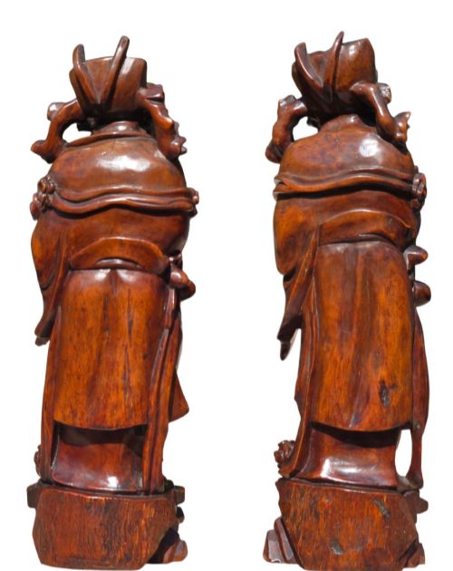 fig 1. A pair of Chinese hardwood sculptures depicting Daoist immortals in flowing robes with carved geometric bases.