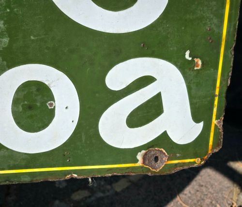 fig 3. A large rectangular bottle green enamel sign featuring white and yellow typography for Rowntrees Elect Cocoa with a royal crest.
