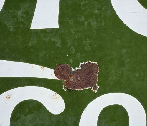 fig 4. A large rectangular bottle green enamel sign featuring white and yellow typography for Rowntrees Elect Cocoa with a royal crest.