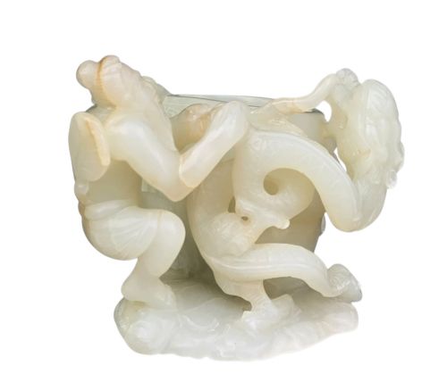 fig 1. A carved pale celadon jade brush washer featuring human figures and a coiled dragon surrounding a central basin.