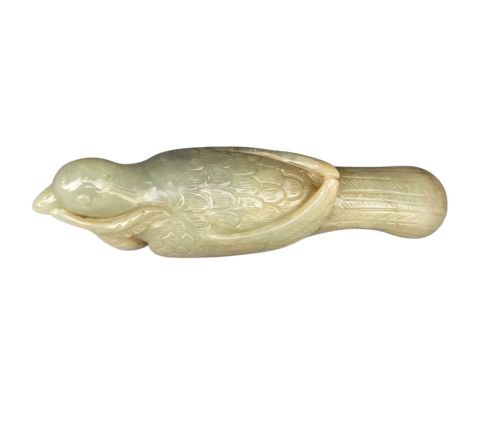 fig 2. A carved celadon jade figure depicting a resting water bird holding a leafy stem in its beak.