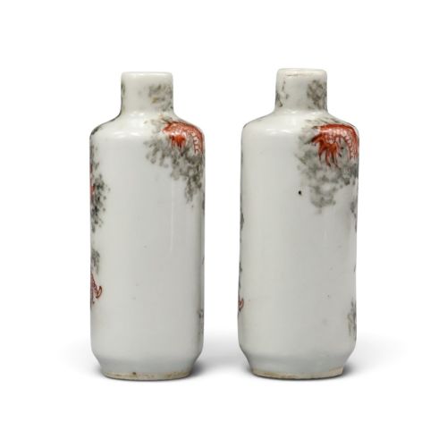 fig 1. A matched pair of cylindrical off-white Chinese porcelain snuff bottles decorated with detailed iron-red dragons amongst grey clouds.