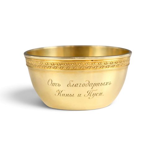 fig 1. A circular gold silver-gilt presentation bowl featuring an engraved monogram and a carved leaf border near the upper rim.
