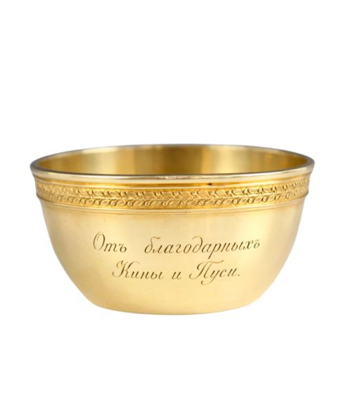 fig 3. A circular gold silver-gilt presentation bowl featuring an engraved monogram and a carved leaf border near the upper rim.