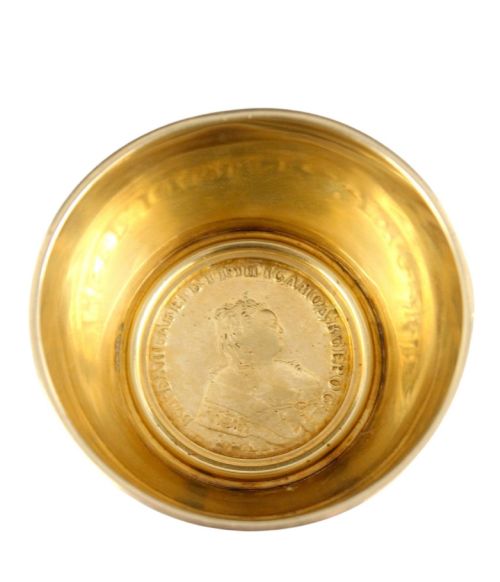 fig 5. A circular gold silver-gilt presentation bowl featuring an engraved monogram and a carved leaf border near the upper rim.