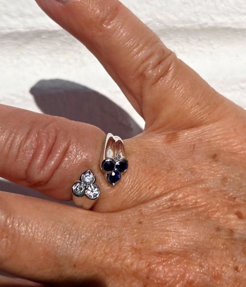 fig 3. A mid-century 18ct white gold crossover ring features opposing trefoil terminals set with blue sapphires and brilliant-cut diamonds.