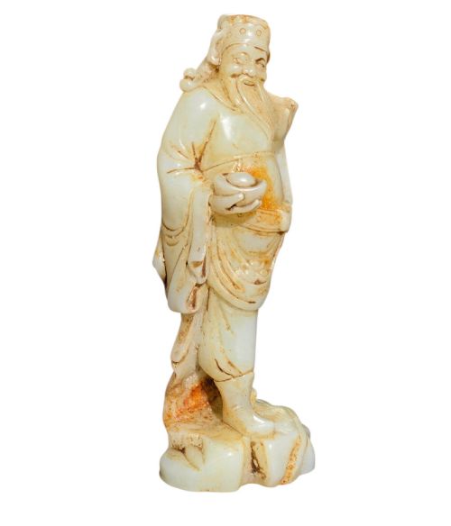 fig 2. A carved pale celadon and russet nephrite jade standing figure of an immortal holding a vessel on a carved rockwork base.