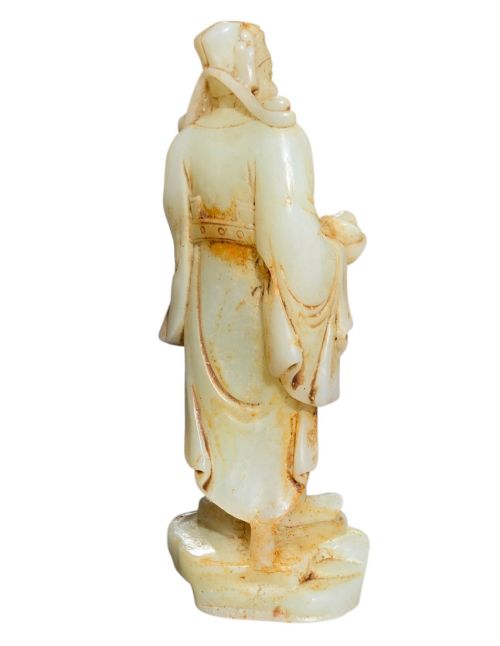 fig 3. A carved pale celadon and russet nephrite jade standing figure of an immortal holding a vessel on a carved rockwork base.