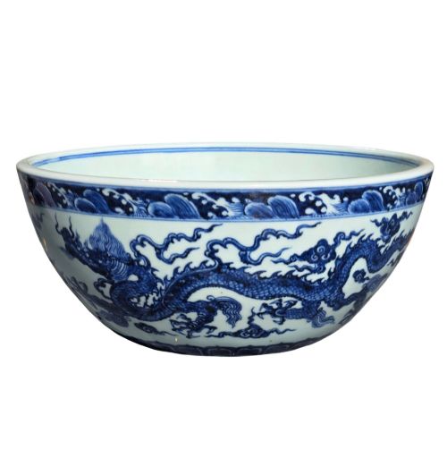 fig 2. A large circular porcelain bowl featuring hand-painted cobalt blue dragons and wave motifs against a white ground.