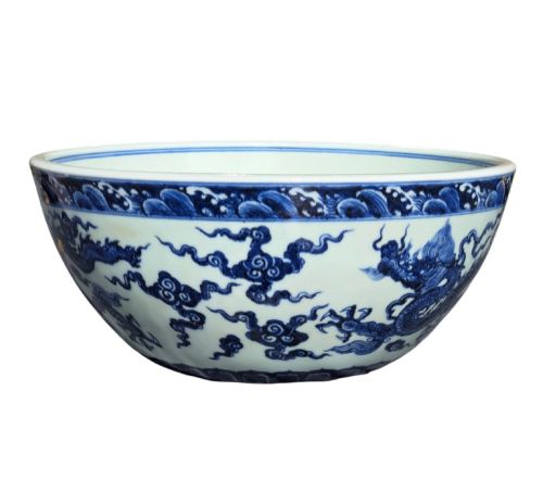 fig 3. A large circular porcelain bowl featuring hand-painted cobalt blue dragons and wave motifs against a white ground.