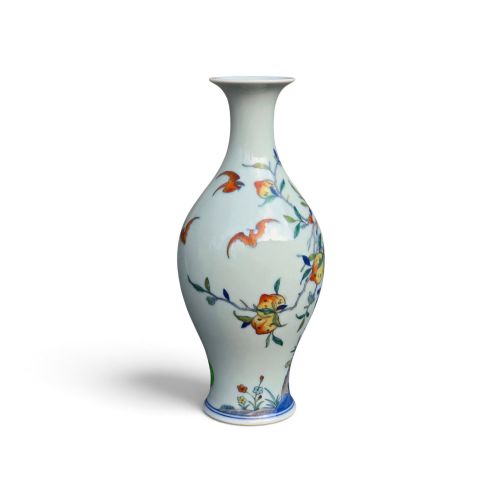 fig 3. A Chinese porcelain garlic-head vase decorated with hand-painted peaches, orange bats, green leaves, and blue rockwork on a white background.
